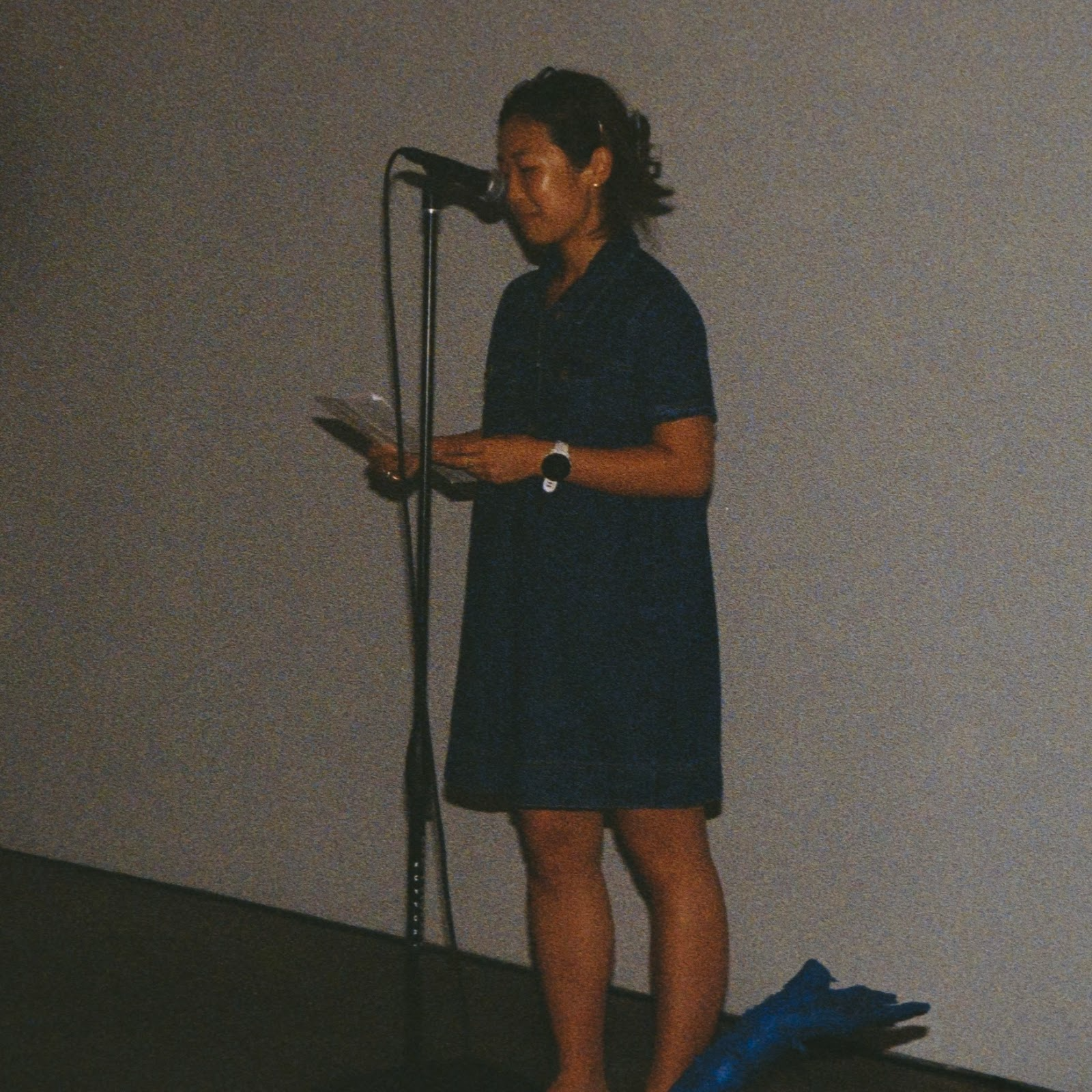 Xiadi reading at a microphone
